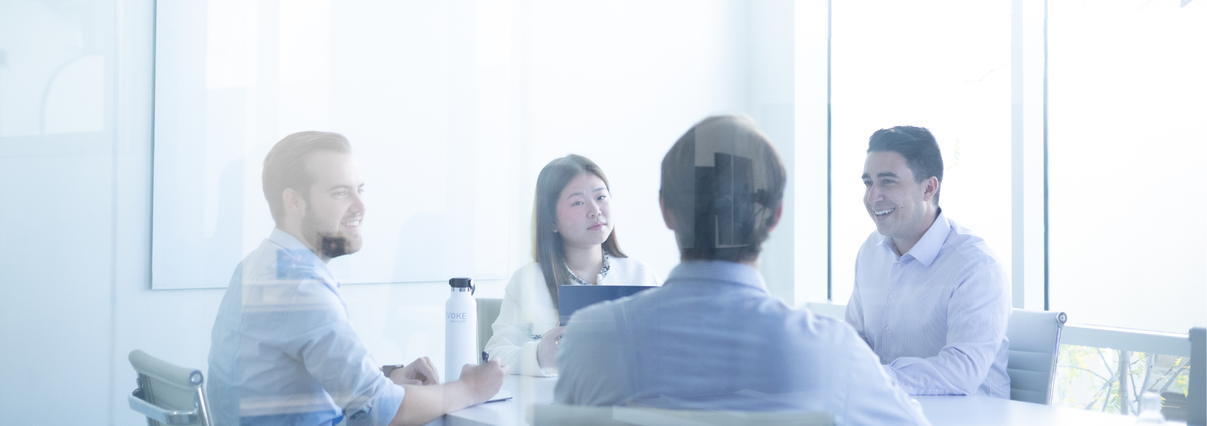 4 co-workers smiling in conference room